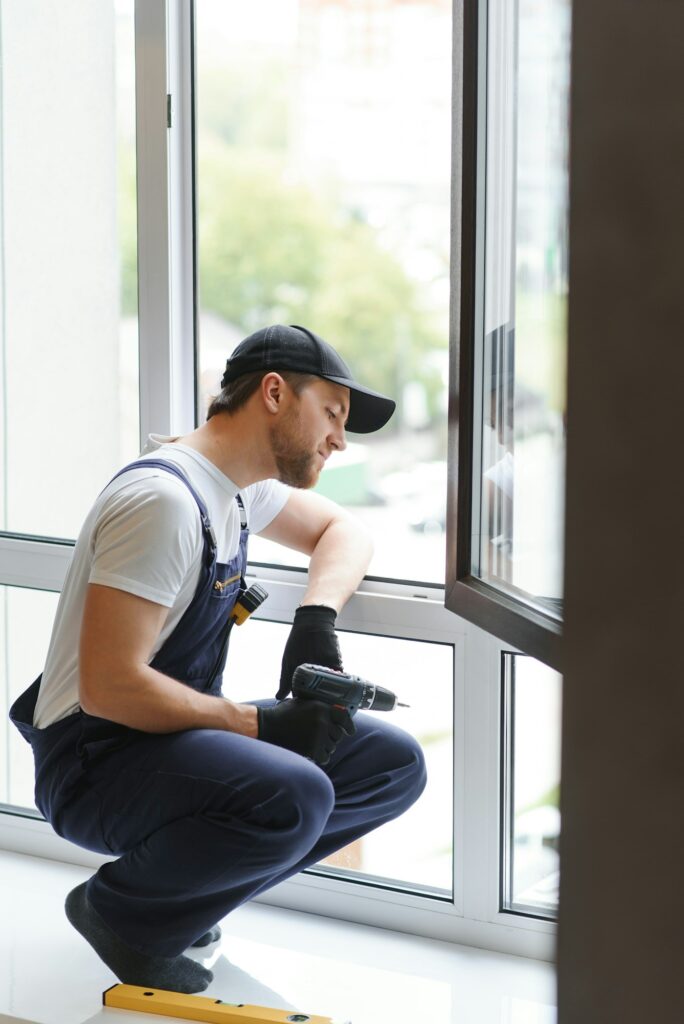 service man installing window with measure tape